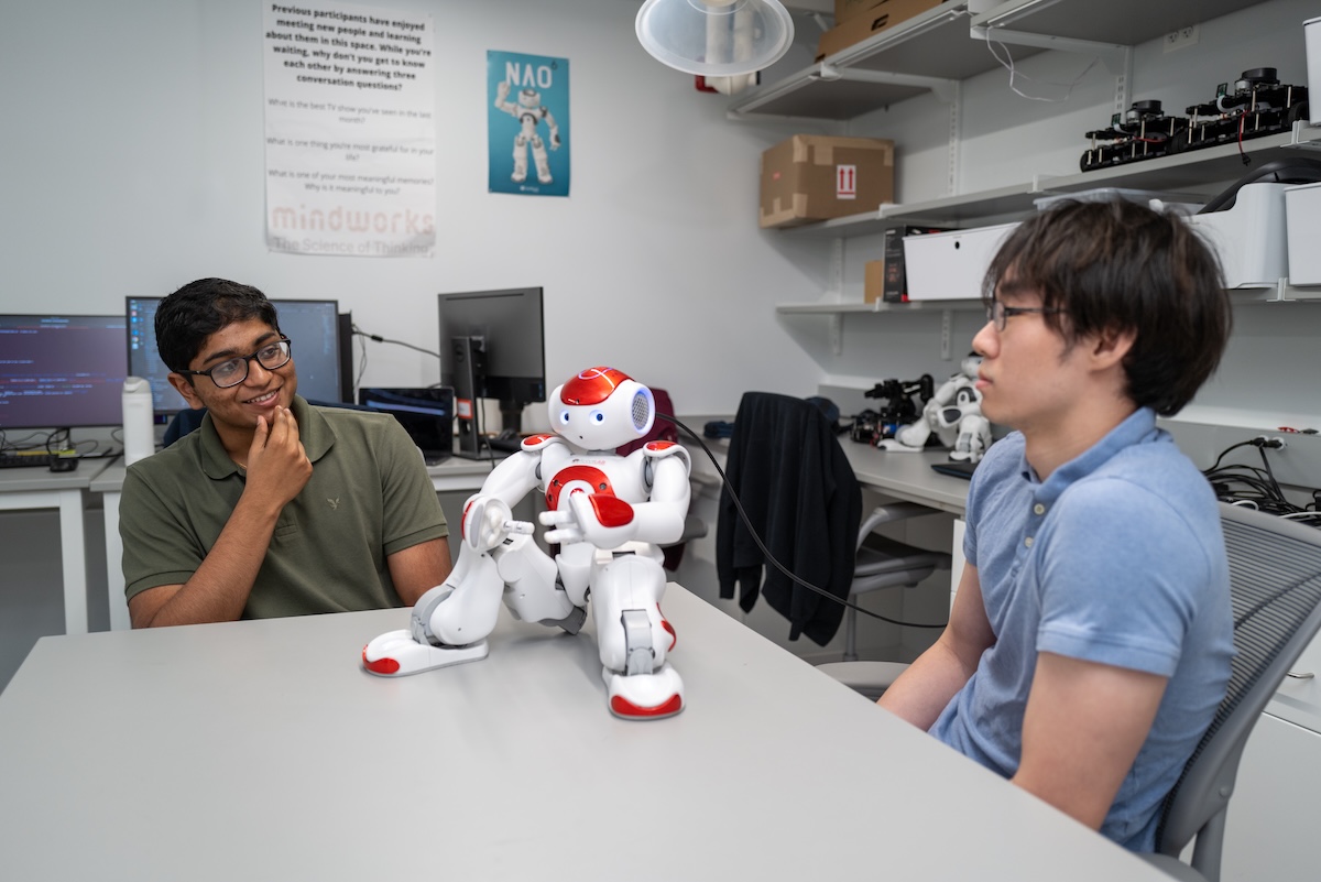 Two people talking with a robot
